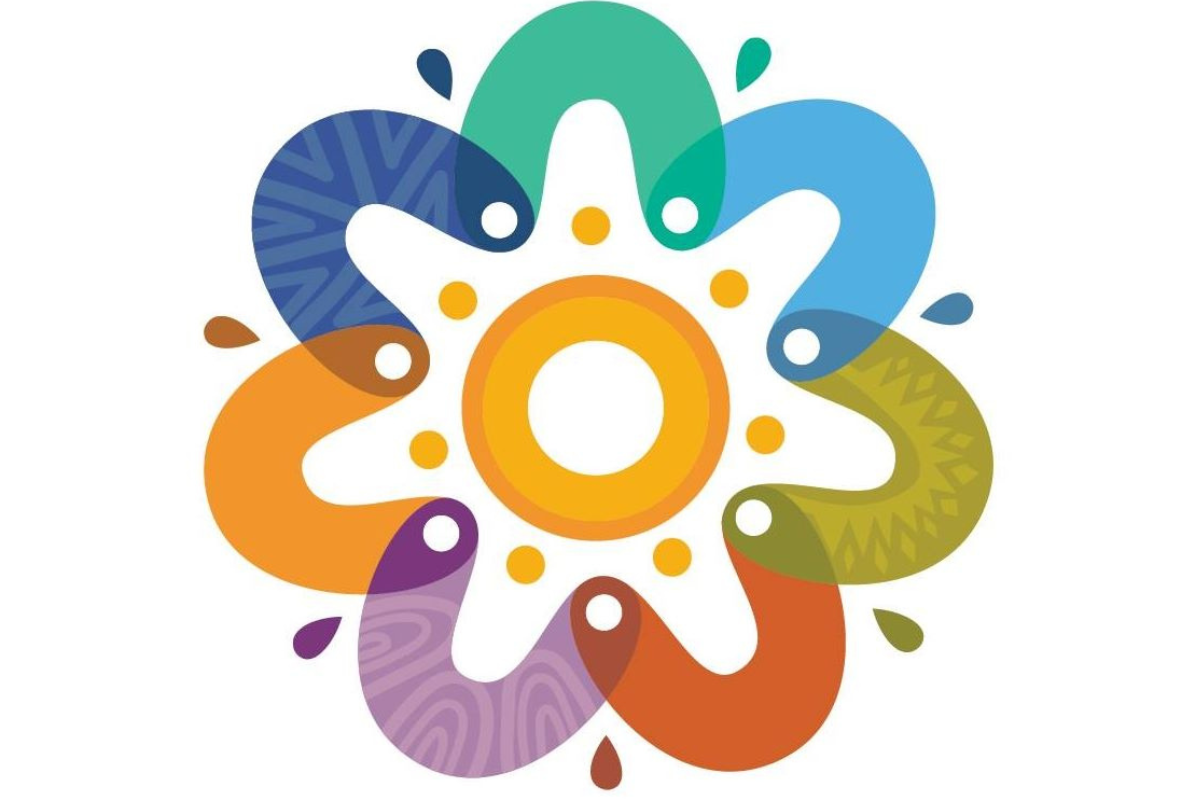 A vibrant circular design featuring interconnected boomerang shapes in multiple colours (blue, green, yellow, orange, and purple) with intricate patterns. At the centre is a golden ring surrounded by dots, symbolising unity, connection, and cultural heritage. The overlapping elements create a dynamic, harmonious effect, representing diversity and collaboration.